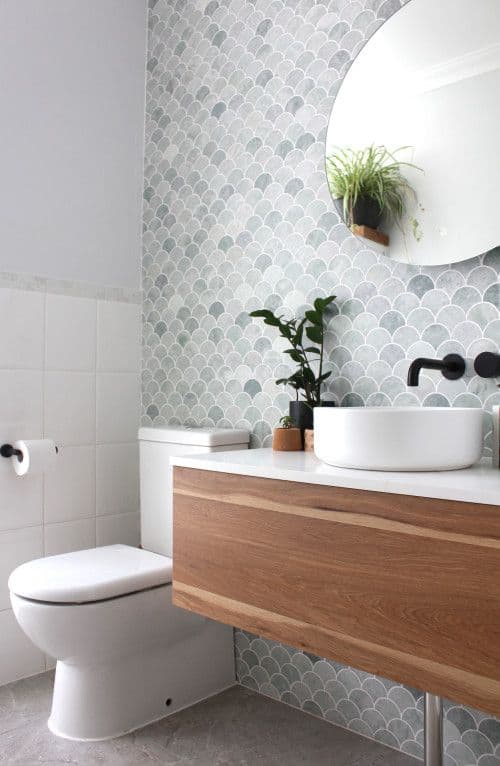 Bright modern small bathroom featuring a floating vanity, frameless glass shower, large-format porcelain tile, recessed storage, and a large mirror to maximize the feeling of space.