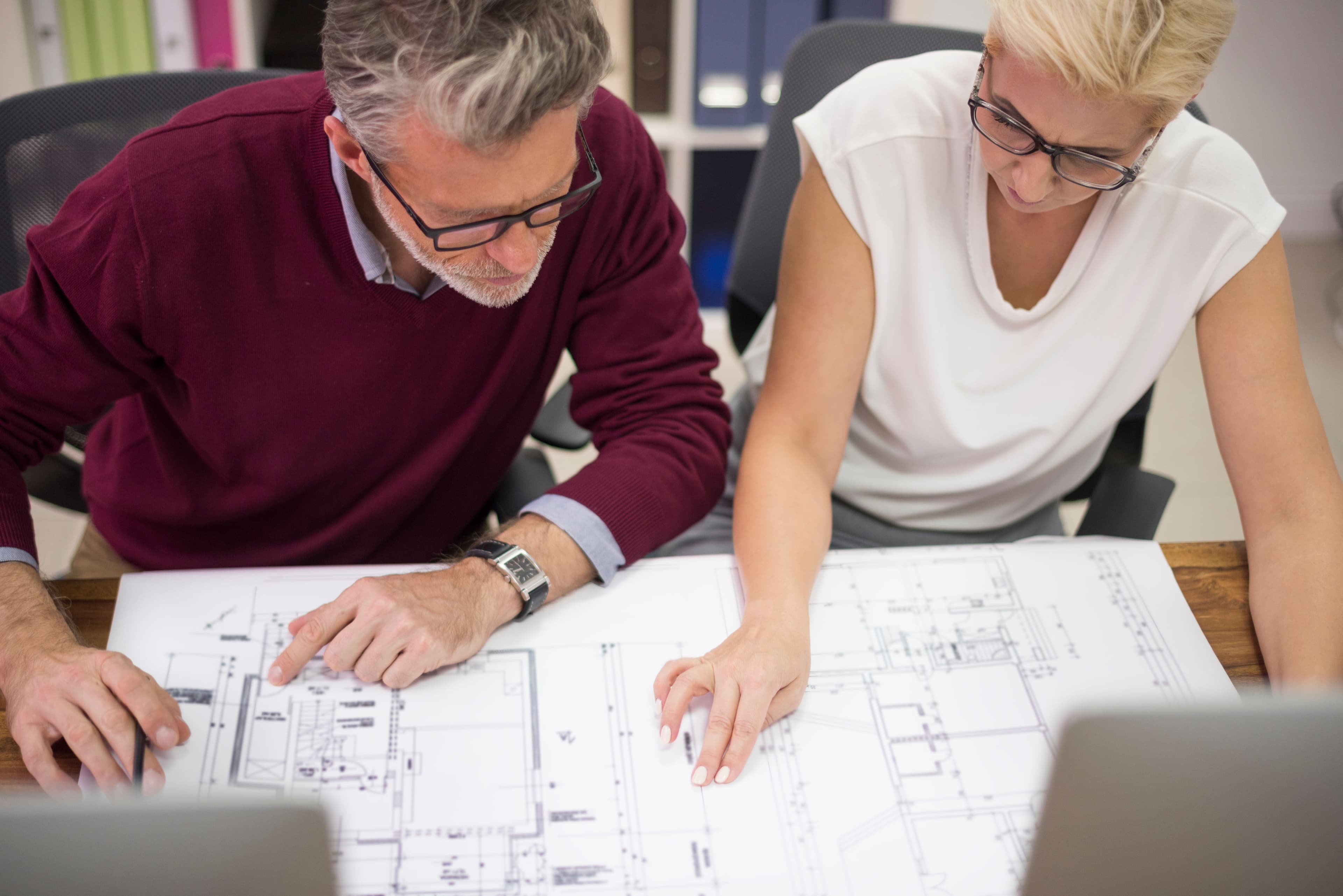 Professional contractor reviewing bathroom remodeling plans and construction details with homeowners.