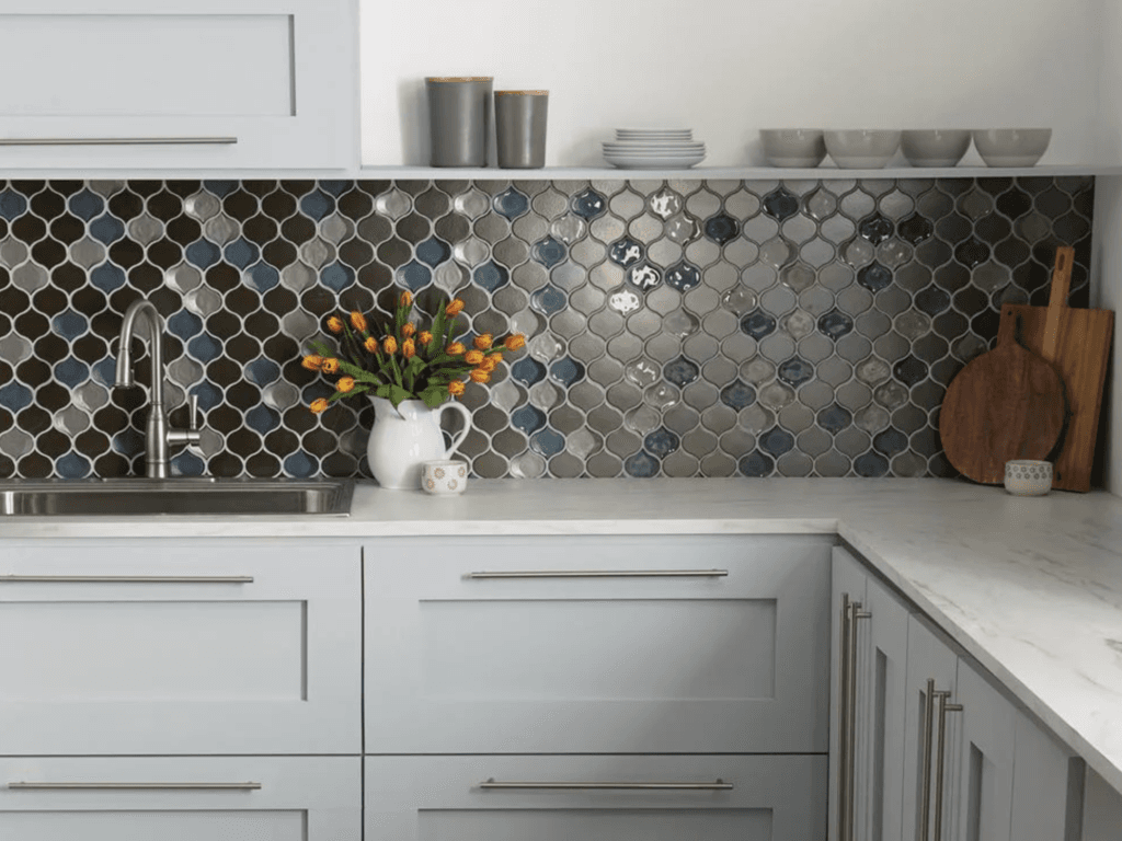 Elegant budget-friendly kitchen remodel with modern lighting, stylish cabinet hardware, and a full-height tile backsplash